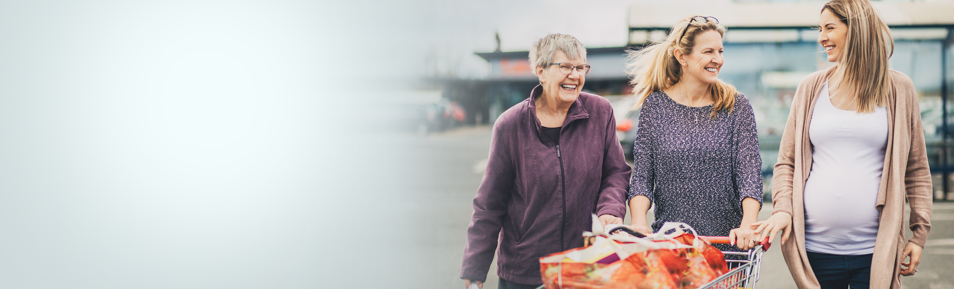 three adults waking with shopping cart