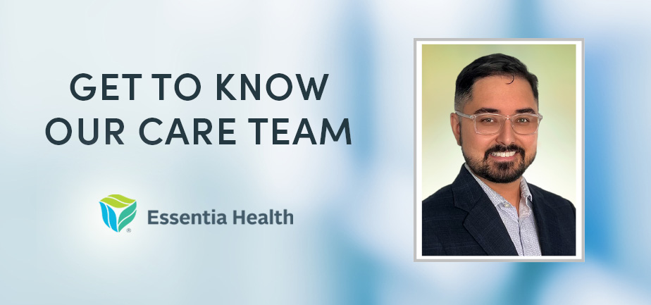 man with dark hair and glasses smiling