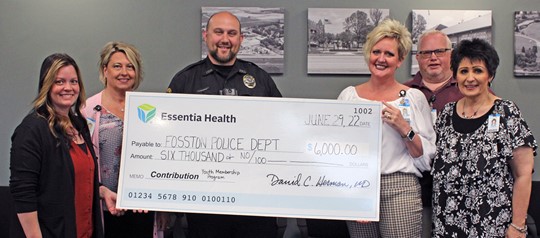 group standing with giant check