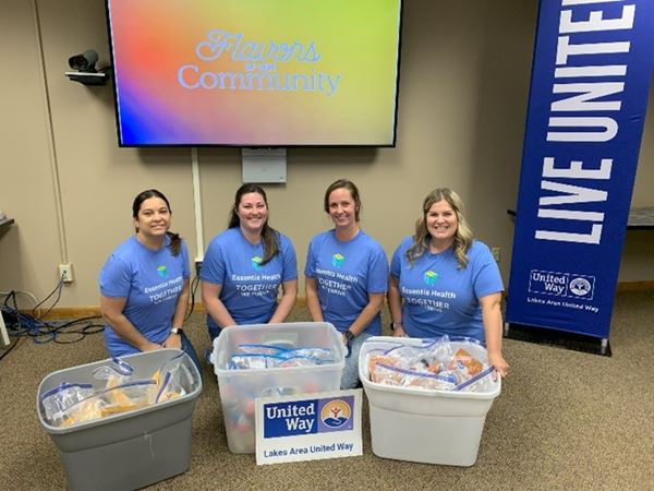 Voluteers with plastic bins and United-Way sign