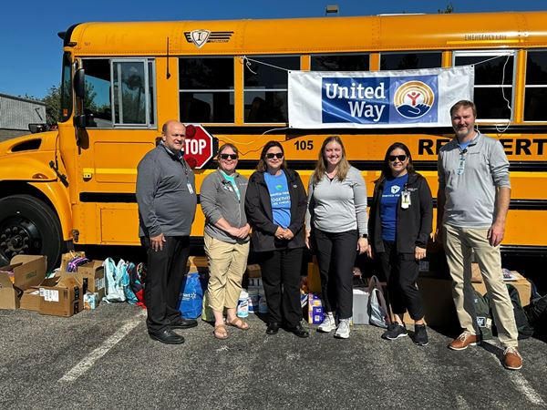 six colleagues standing by a bus