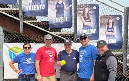 5 adults, one holding softball.