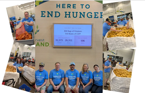 'Here to End Hunger’ banner with smiling Essentia staff and volunteers organizing food